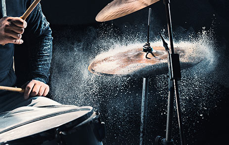 Musician hitting symbols on a drum kit